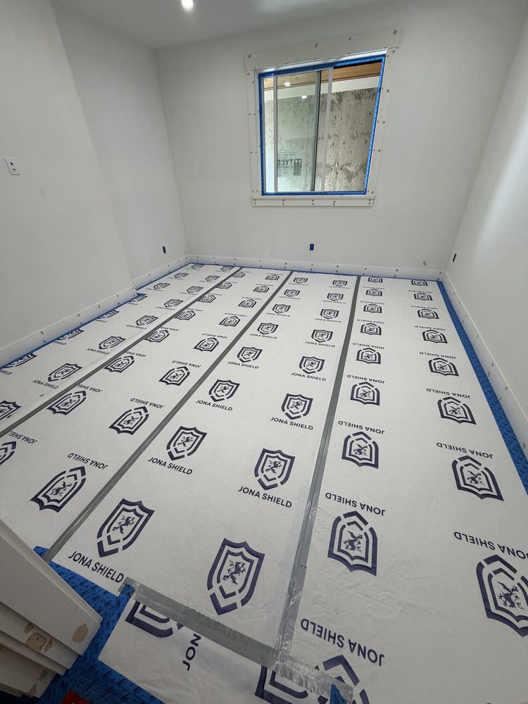 Jona Shield floor protection taped down wall to wall before drywall work on a Mad-Dogs job